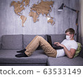 man in quarantine for Coronavirus wearing protective medical mask and smart working at home 63533149