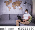 man in quarantine for Coronavirus wearing protective medical mask and smart working at home 63533150