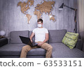 man in quarantine for Coronavirus wearing protective medical mask and smart working at home 63533151