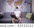 man in quarantine for Coronavirus wearing protective medical mask and smart working at home 63533152