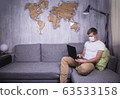 man in quarantine for Coronavirus wearing protective medical mask and smart working at home 63533158