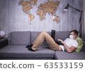 man in quarantine for Coronavirus wearing protective medical mask and smart working at home 63533159