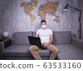 man in quarantine for Coronavirus wearing protective medical mask and smart working at home 63533160