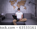 man in quarantine for Coronavirus wearing protective medical mask and smart working at home 63533161