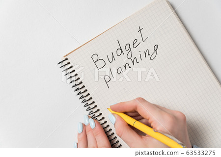 Budget planning concept. Female hand holding pen 63533275