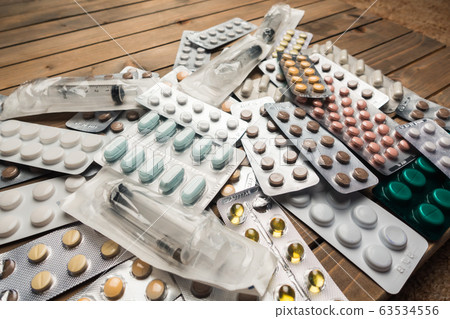 Closeup shot of different pills on table with tablets , pharmaceutical industry concept 63534556