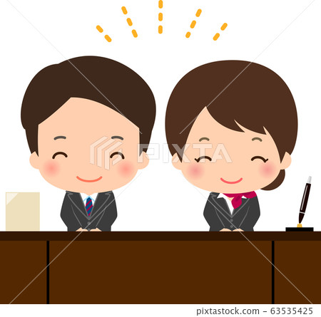 Male and female staff at hotel reception 63535425