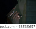 Vaper / A man smoking an electronic cigarette in a dark room 63535657
