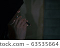 Vaper / A man smoking an electronic cigarette in a dark room 63535664