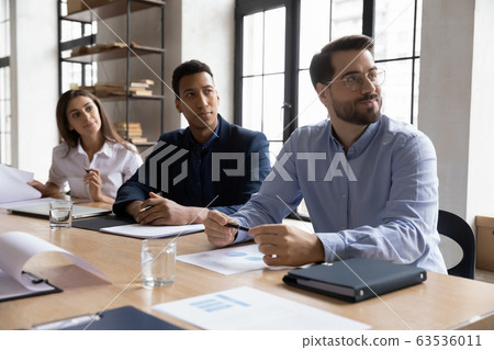 Multiracial businesspeople listen to office presentation or training 63536011