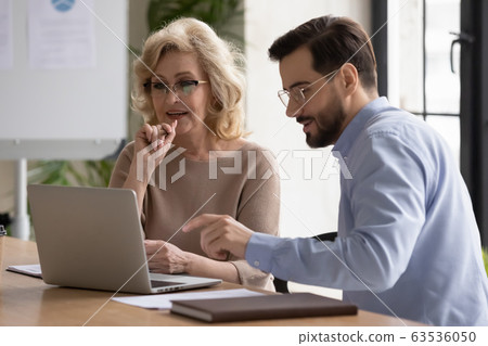 Focused diverse colleagues cooperating at meeting in office Focused diverse colleagues cooperating at meeting in office 63536050