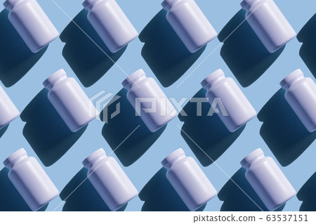 Repeating white cans of pills on a blue background Repeating white cans of pills on a blue background 63537151