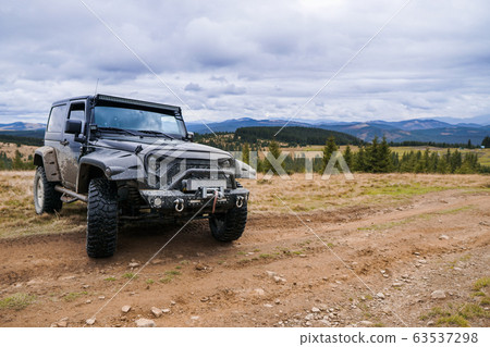 Black jeep parked by the road with picturesque 63537298