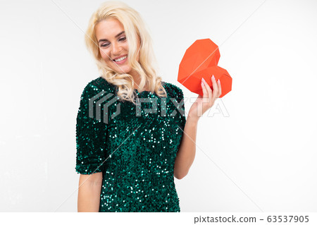 blonde playing sexy girl in a green dress holding a paper red heart on a white background with copy blonde playing sexy girl in a green dress holding a paper red heart on a white background with copy 63537905