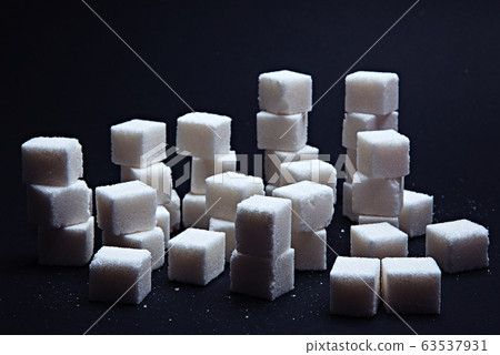 Pile of sugar cubes on a black background. Pile of sugar cubes on a black background. 63537931