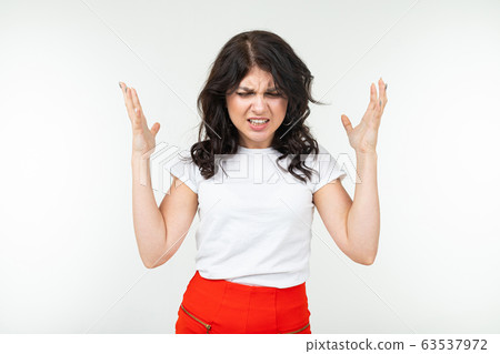 indignant brunette girl in a white tank top fed up waving her arms on a white studio background indignant brunette girl in a white tank top fed up waving her arms on a white studio background 63537972