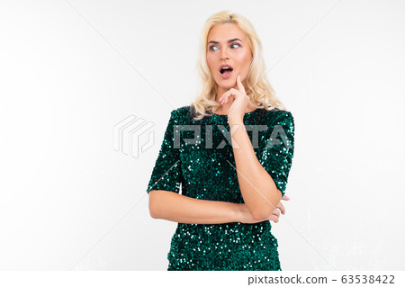 surprised blonde girl in a green elegant dress on a white background with copy space surprised blonde girl in a green elegant dress on a white background with copy space 63538422