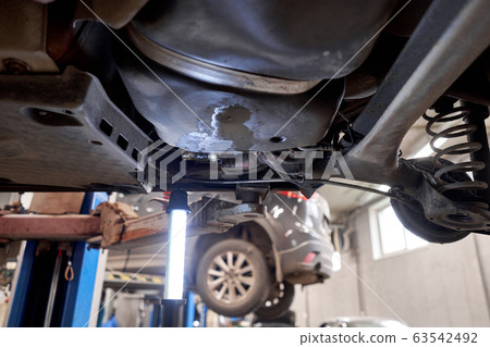 Rusty drum brakes, rear on red car. Change the old to new brake disc on car in a garage. Auto mechanic repairing 63542492