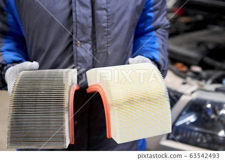 New and old dirty automotive engine air filter in the hands of an auto mechanic. Auto repair concept. 63542493
