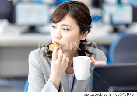Business woman eating a snack Business woman eating a snack 63543979