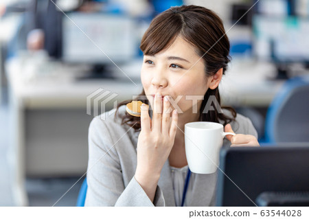 Business woman eating a snack Business woman eating a snack 63544028