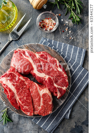 Raw beef steak on dark gray background Raw beef steak on dark gray background 63544177