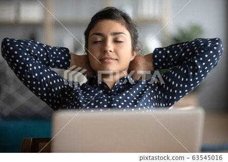 Head shot peaceful Indian girl leaning back in chair 63545016