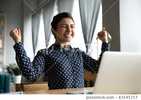 Smiling Indian woman excited by good news, work success Smiling Indian woman excited by good news, work success 63545157