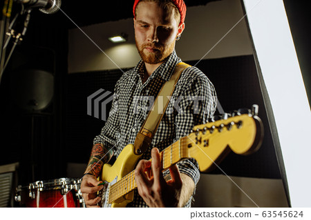 handsome guy enjoy playing electric guitar 63545624