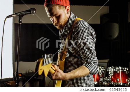 caucasian rock musician play on electric guitar 63545625