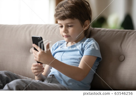 Little preschooler boy using smartphone at home Little preschooler boy using smartphone at home 63546256
