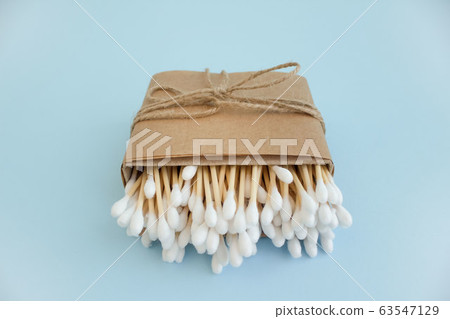 Bamboo cotton sticks or swabs in paper box bound with flax or hemp cord on blue background. Copy space, zero waste concept, eco friendly 63547129