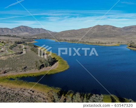 Aerial view of Otay Lake Reservoir with blue sky and mountain 63547320