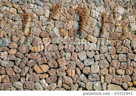 Heart shape stone and wall near Megane-bashi spectacles bridge in Nagasaki, Japan 63552941