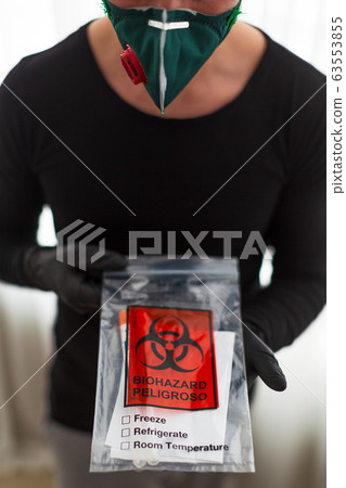 man in a protective mask holds a test 63553855