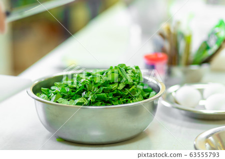 Cook in the kitchen cuts greens close up 63555793