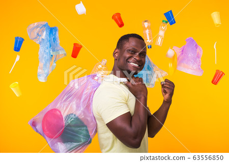 Problem of trash, plastic recycling, pollution and environmental concept - funny man carrying garbage bag on yellow background Problem of trash, plastic recycling, pollution and environmental concept - funny man carrying garbage bag on yellow background 63556850