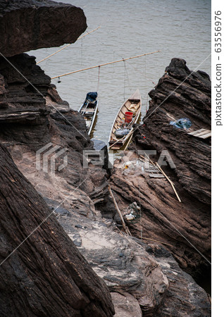 Canyon cliff shoreline of Mekong river and local fisherman Canyon cliff shoreline of Mekong river and local fisherman 63556976