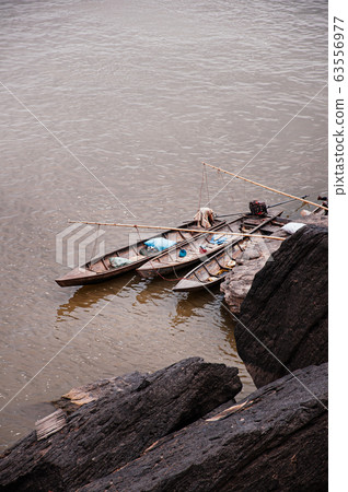 Canyon cliff shoreline of Mekong river and local fisherman 63556977
