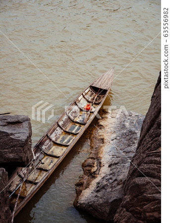 Canyon cliff shoreline of Mekong river and local fisherman boat Canyon cliff shoreline of Mekong river and local fisherman boat 63556982