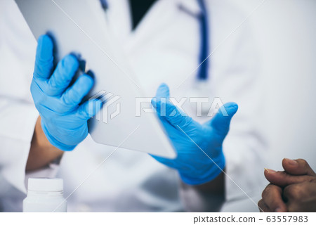 Asian male doctor with tablet pc, medicine and 63557983