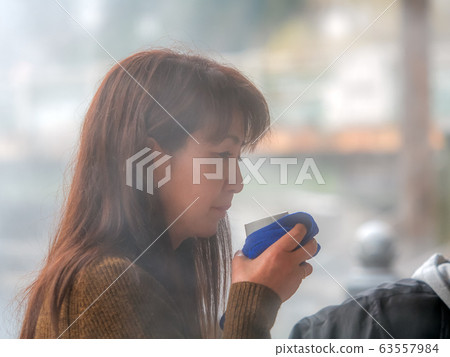 Hot spring town Women enjoying drinking spring Portrait 63557984