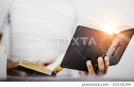 Young man with bible while reading, believe 63558290