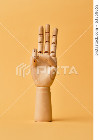 Wooden human hand with three fingers raised up Wooden human hand with three fingers raised up 63559655