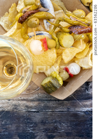 Tapas, top view. Wine and gildas, spicy pinchos, on potato chips with copy space 63562286