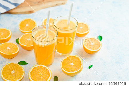 orange juice in a glass, top view, slices of oranges, straw, healthy lifestyle concept orange juice in a glass, top view, slices of oranges, straw, healthy lifestyle concept 63563926