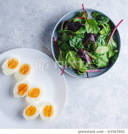 green salad with egg in a blue bowl on a blue background 63563992