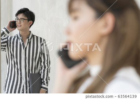 年輕的男人和女人在戶外的智能手機 年輕的男人和女人在戶外的智能手機 63564139