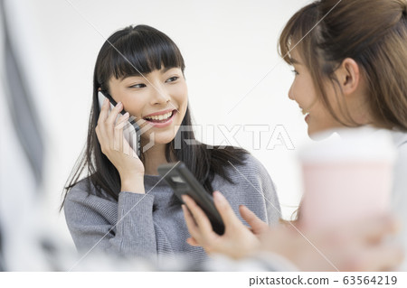 少婦和朋友觀看智能手機戶外 少婦和朋友觀看智能手機戶外 63564219