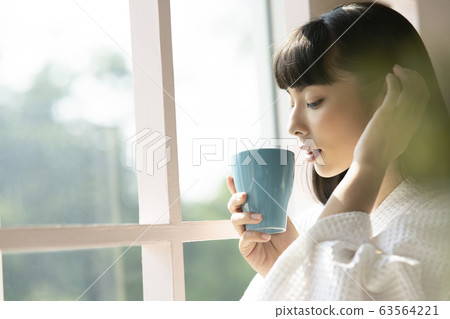 女人抱著一大杯放鬆在室內 女人抱著一大杯放鬆在室內 63564221